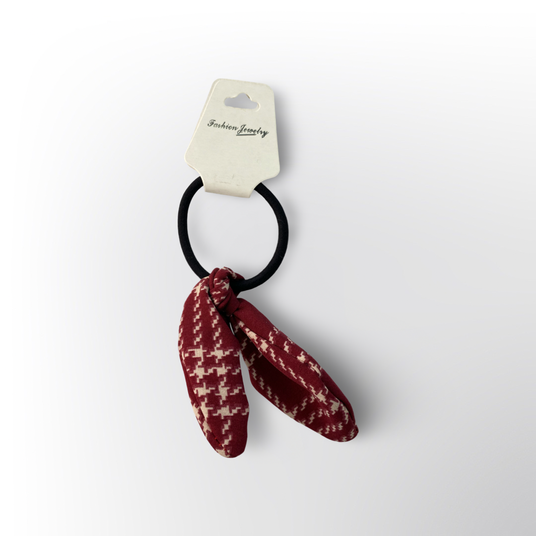 Coletero con Lazo de Tela 🧣 – Liga negra con lazo de tela en tono rojo vino y estampado beige tipo pata de gallo, ideal para darle un toque elegante y moderno al peinado.